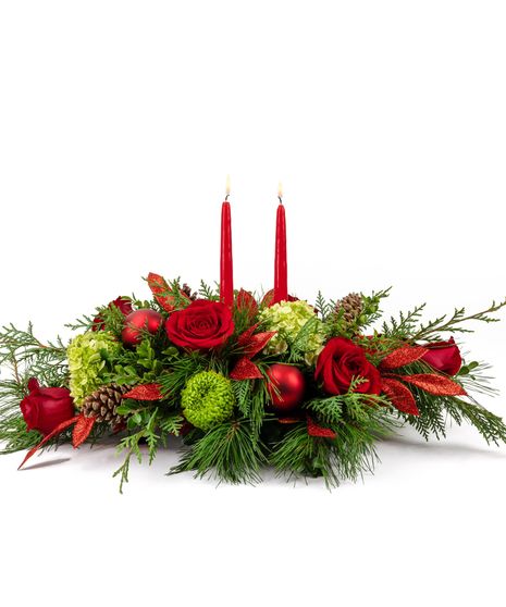 This arrangement, artfully designed in a keepsake basket with red cremones and anemones, white stock, pine cones, and winter greenery help bring playfulness to the holiday. 