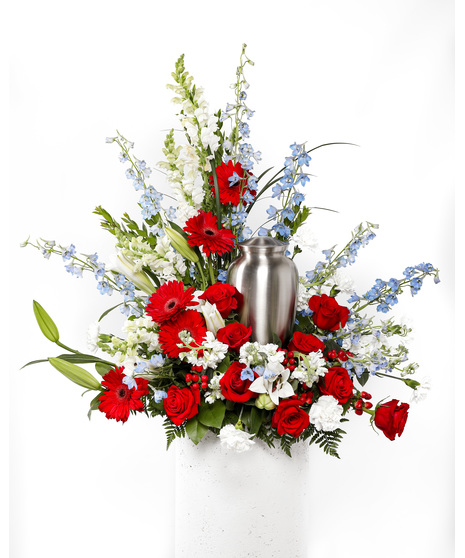 A bold display of vibrant red florals and a touch of blue and white makes the perfect patriotic fireworks display for a cremation urn or photograph.