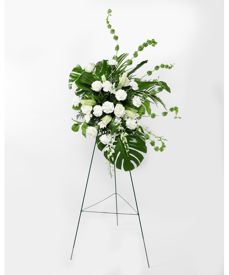 This display of white blooms is artfully arranged amongst lush greenery creating an outstanding way to honor the life of your loved one. 